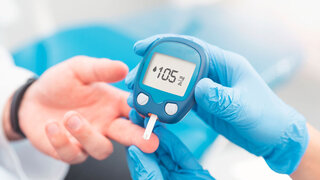 Doctor checking blood sugar level with glucometer. Treatment of diabetes concept.