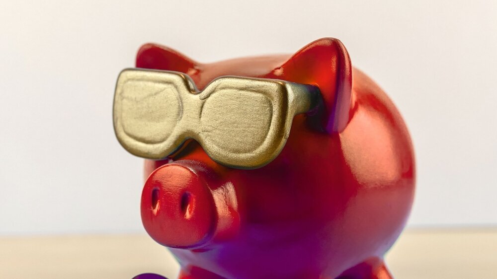 cool red piggy bank with golden glasses with toothbrush and dentist equipment isolated on wooden table, treasure
