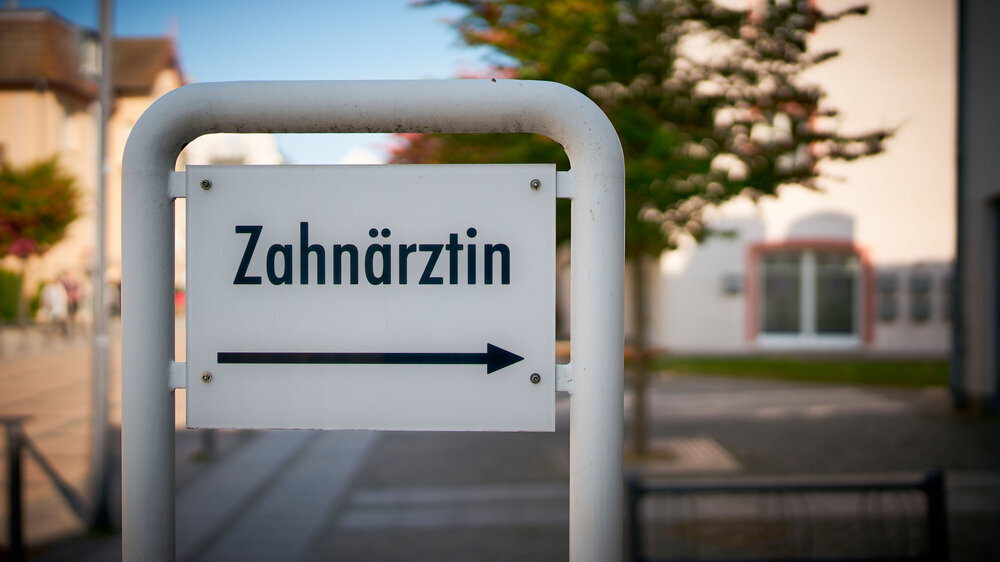 Schild vor einer Zahnarztpraxis mit der Aufschrift Zahnärztin Praxisschild Zahnärztin