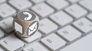 Themenfoto Kontaktoptionen zeigt Würfel mit den Symbolen Telefonhörer, Messenger und Brief