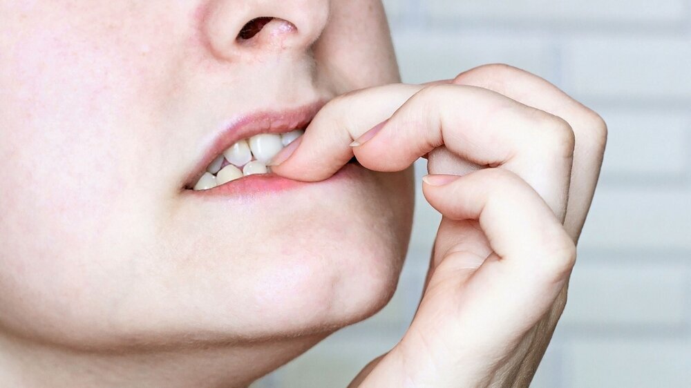 Young nervous caucasian woman bitting nails close up. Anxious, stressed, frustrated, embarrassed, neurotic, confused person concept. Nägelkauen