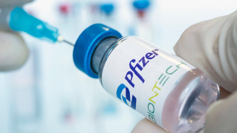 Vials of liquid the logos pfizer and biontech in the doctor's hand Impfung Biontech Pfizer