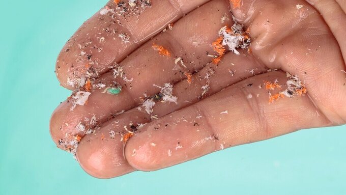 Mikroplastik aus verschmutztem Wasser auf einer Hand Mikroplastik aus verschmutztem Wasser auf einer Hand