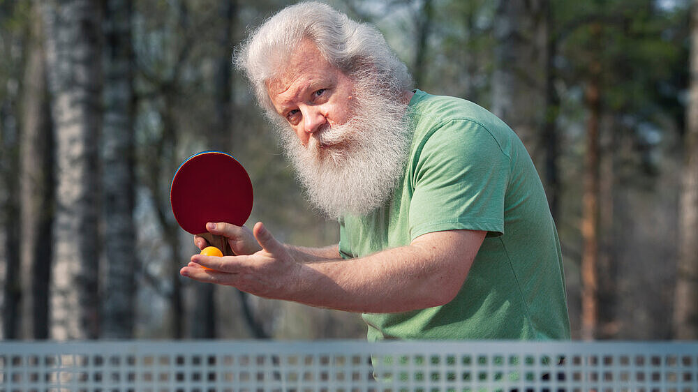Senior spielt Tischtennis im Freien. Senior spielt Tischtennis im Freien.