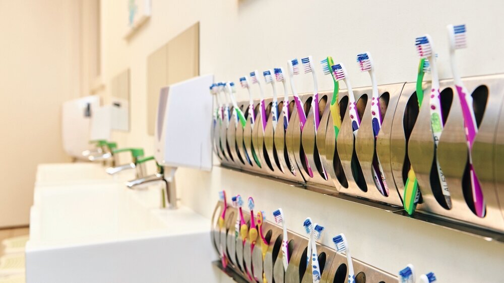 Clean bathroom in daycare or kindergarten with many toothbrushes