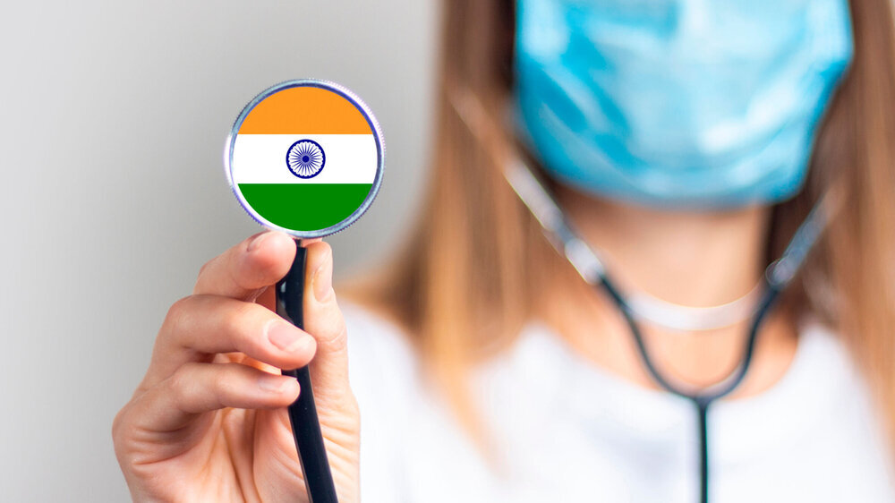 female doctor in a medical mask holds a stethoscope on a light background. Added flag of India. Concept medicine, level of medicine, virus, epidemic. Baner.