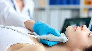 Increase in submandibular lymph nodes and doctor conducts ultrasound. Ultrasound examination of lymph nodes in woman in clinic