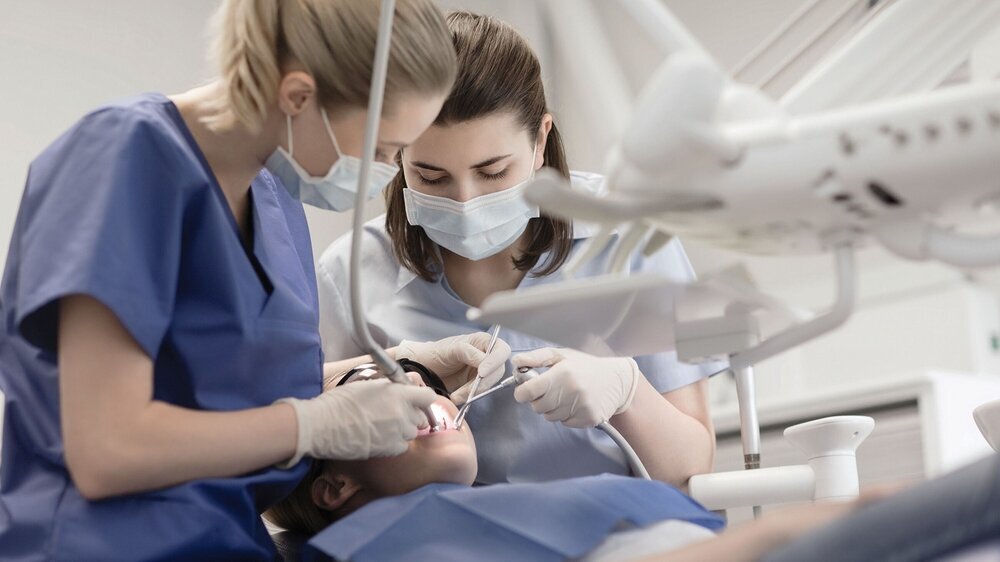 female dentists treating patient girl teeth Zahnärztin