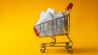 Der Zucker in Stücken liegt im Einkaufskorb.