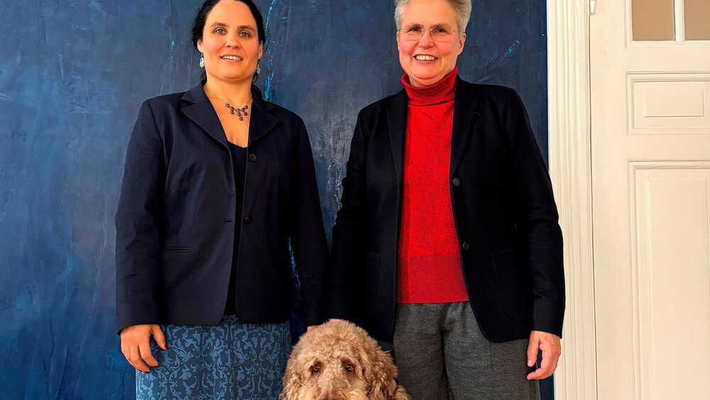 Maike Baumann und Anke Handrock mit Praxishund in den neuen Räumlichkeiten in Berlin.
