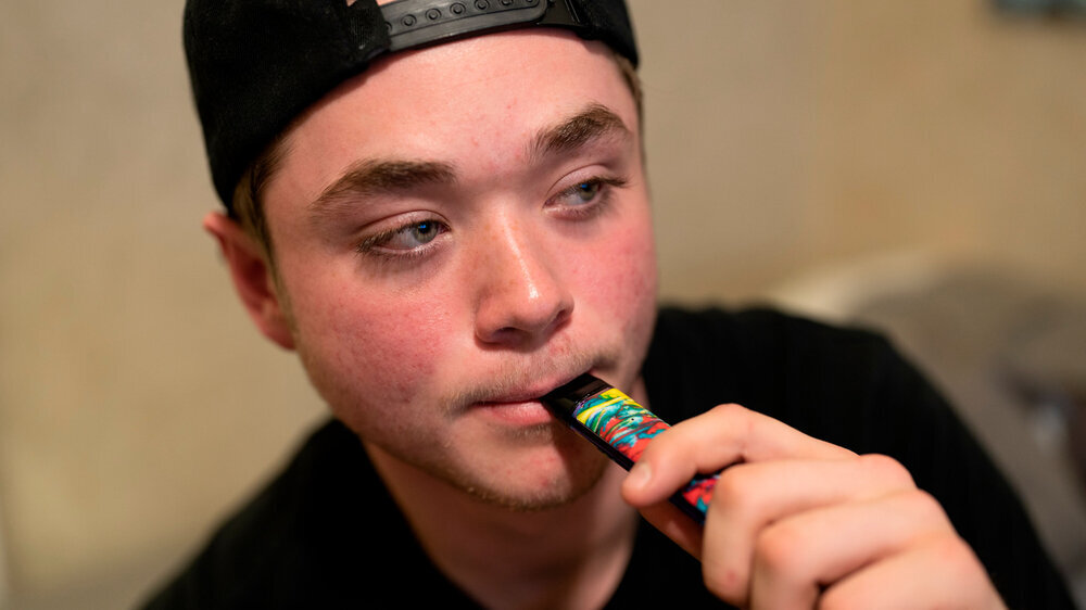 teen is getting ready to vape with THC Teenager mit E-Zigarette, Vape