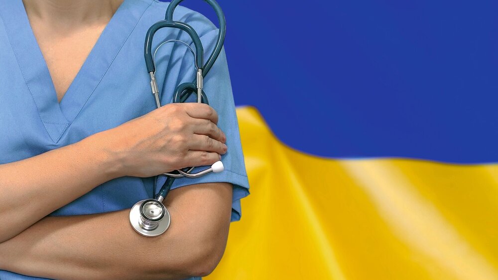Female surgeon or doctor with stethoscope in hand on the background of the Ukraine flag. Surgery concept in Ukraine