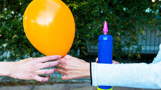 Zwei Männer reichen sich Ballon mit der Partdroge Lachgas weiter