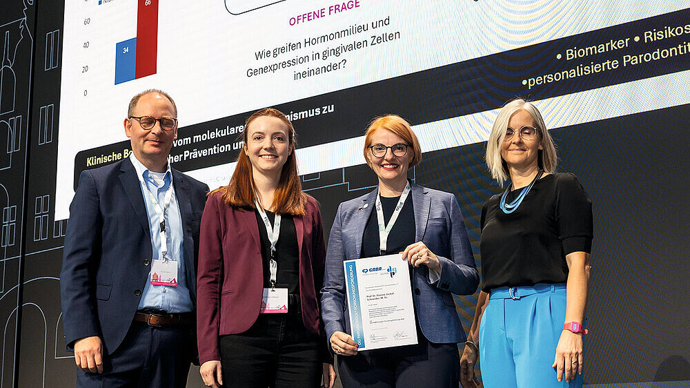 Den zweiten Platz für Forschungsförderung erhielt Prof. Dr. Yvonne Jockel-Schneider, M.Sc. (3. v. l., Lehrstuhl für Parodontale Medizin und Geriatrische Zahnmedizin, Julius-Maximilians-Universität Würzburg) für ihr Forschungsvorhaben „Hormonabhängige posttranskriptionelle Regulation als Schlüsselmechanismus geschlechtsspezifischer Parodontitis: Funktionelle Analyse von CPEB1 und CPEB4 in patientennahen Modellen“. Das Forschungsprojekt zielt darauf, Wissenslücken bezüglich der mechanistischen Grundlage geschlechtsspezifischer Krankheitsverläufe, speziell des Risikos für schwere Parodontitis bei jungen Frauen, zu schließen und auf diesem Weg wichtige Erkenntnisse für geschlechtsspezifische Präventions- und Therapiestrategien zu gewinnen.