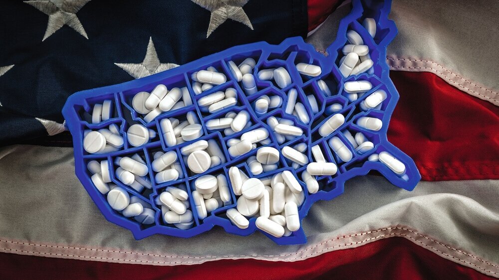 Karte der USA, gefüllt mit Oxycodon und Hydrocodon-Pillen auf der amerikanischen Flagge