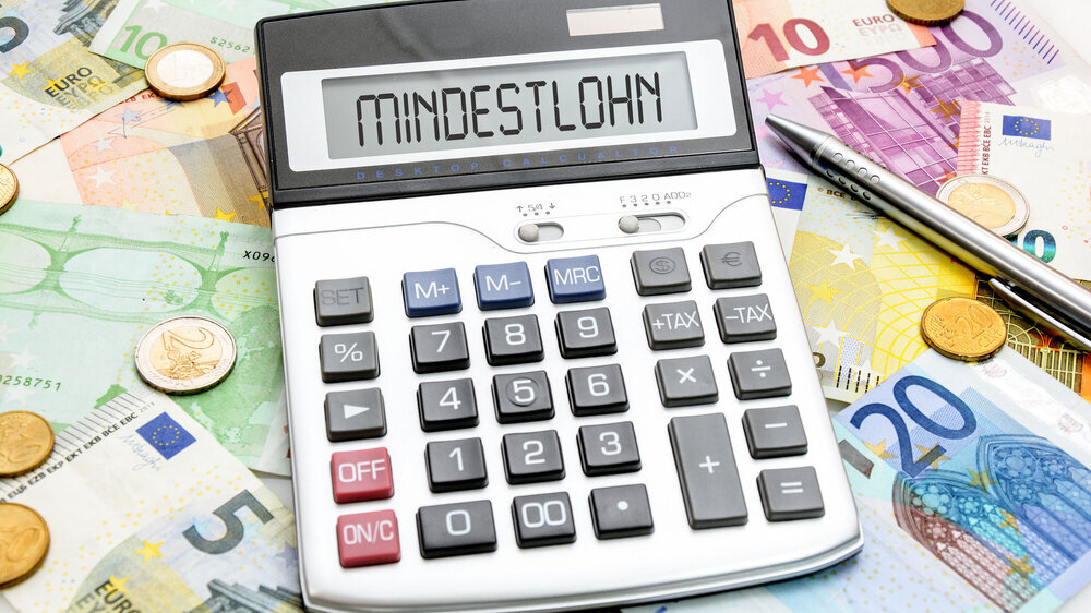 Geldscheine und Münzen zeigen den Mindestlohn. Geldscheine und Münzen zeigen den Mindestlohn.