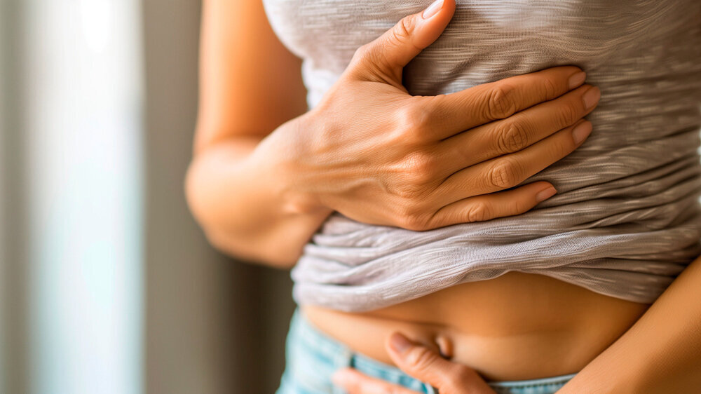 Eine junge Frau hält ihren Bauch