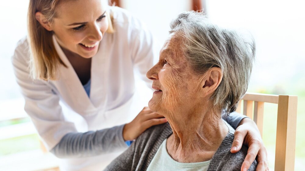 Health visitor and a senior woman during home visit.