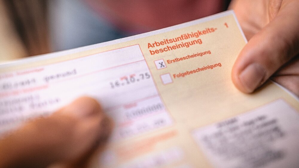 Arbeitsunfähigkeitsbescheinigung wird übergeben.