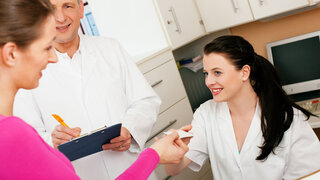 Frau am Empfang einer Arztpraxis