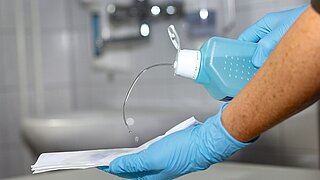Wischdesinfektion der Oberflächen mit Handtüchern und Handschuhen.