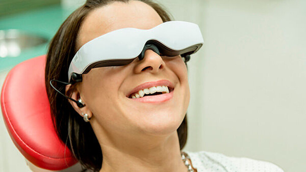 Für Unterhaltung und Entspannung während der Behandlung sorgt eine Videobrille.