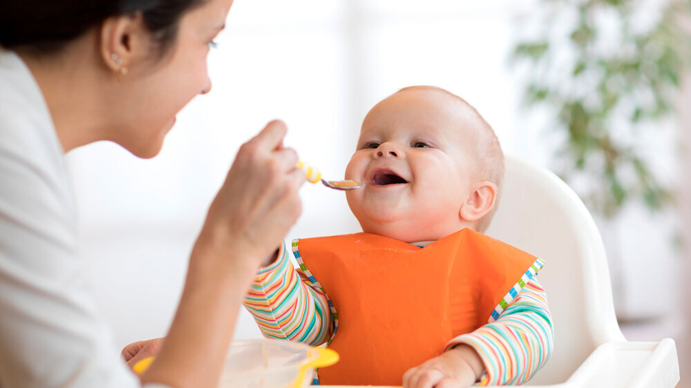 Mutter füttert ihr Baby mit einem Löffel. Mutter füttert ihr Baby mit einem Löffel.