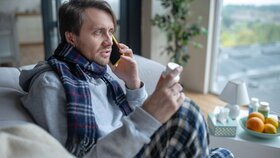 Doctor on phone. Dark-haired sick man wearing scarf speaking with doctor on phone