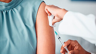 Hands, medical and doctor with patient for vaccine in a clinic for healthcare treatment for prevention. Closeup of a nurse doing a vaccination injection with a needle syringe in a medicare hospital