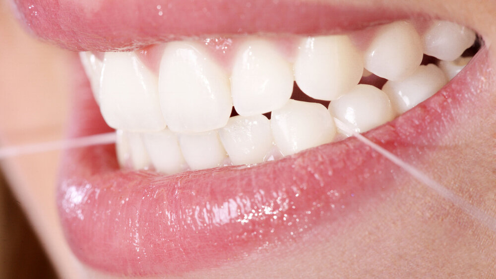 Zahnpflege mit Zahnseide Nahaufnahme