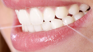 Zahnpflege mit Zahnseide Nahaufnahme