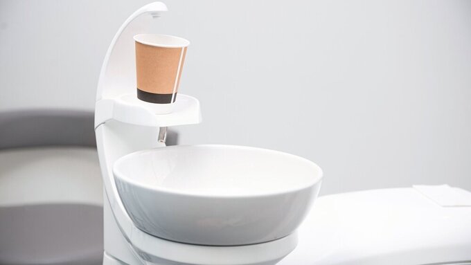Close up photo of dentistry sink with a paper cup on it ready for mouth wash. Pappbecher beim ZA