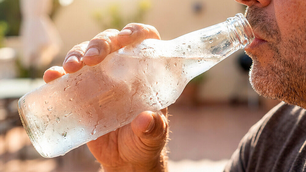 Heatwave Coping man drinking cold water during extreme heat outdoors