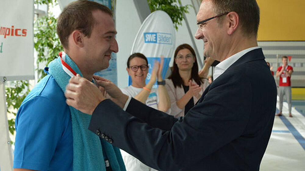 Dr. Christian Junge, Präsident der Landeszahnärztekammer Thüringen, gratulierte dem aktuellen Deutschen Meister der Nationalen Sommerspiele von Special Olympics über 25 Meter Schmetterling, Chris Weiland aus Saalfeld.