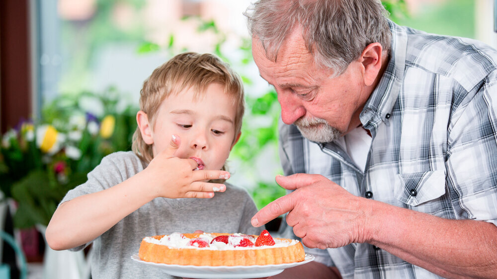 Best grandpa. Two generations of men cooking together. Großvater nascht mit Enkelin Kuchen