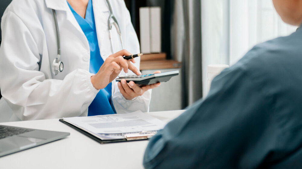 Ärztin rechnet in der Sprechstunde eine Leistung ihres Patienten ab. Ärztin rechnet in der Sprechstunde eine Leistung ihres Patienten ab.
