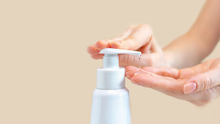 Eine Frau drückt auf eine Flasche mit antibakteriellem Gel zum Reinigen und Waschen der Hände