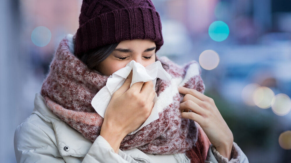 Erkältung Winter draußen - Frau putzt sich die Nase
