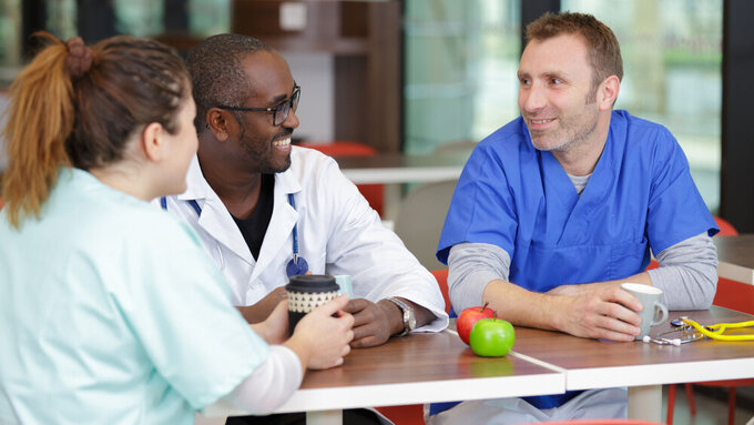 group of doctors relaxing during lunch break Klinikärzte in der Pause