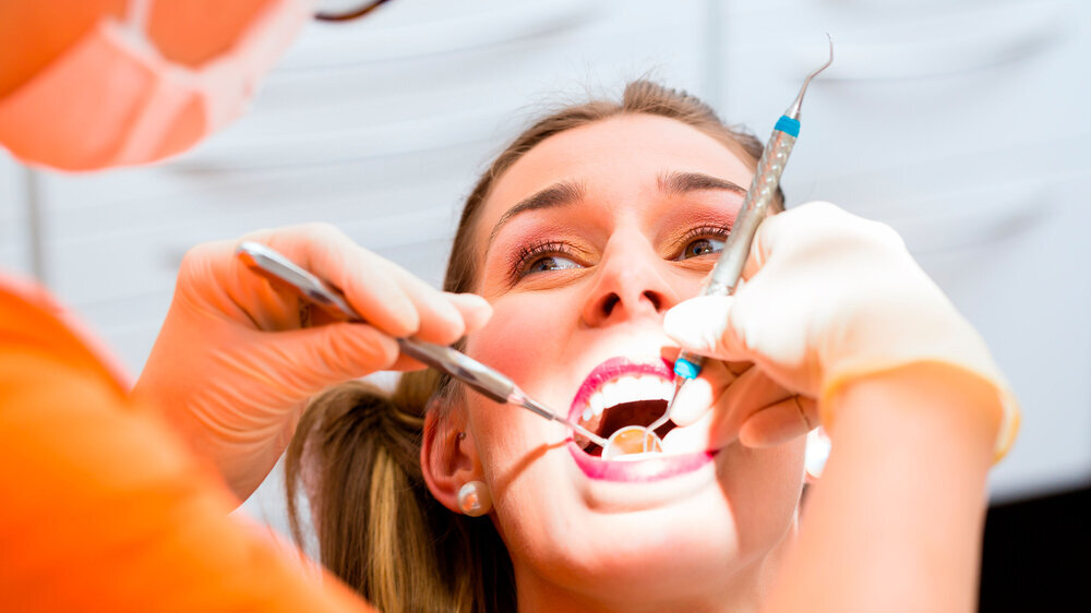 Patient having deep dental tooth cleaning at dentist