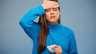 Kranke Frau mit Fieber, die ihre Stirn berührt. Isoliertes Porträt einer weiblichen Person mit geschlossenen Augen.