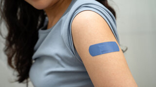 HPV, Human papillomavirus, Asian young woman receiving vaccine with blue bandage.