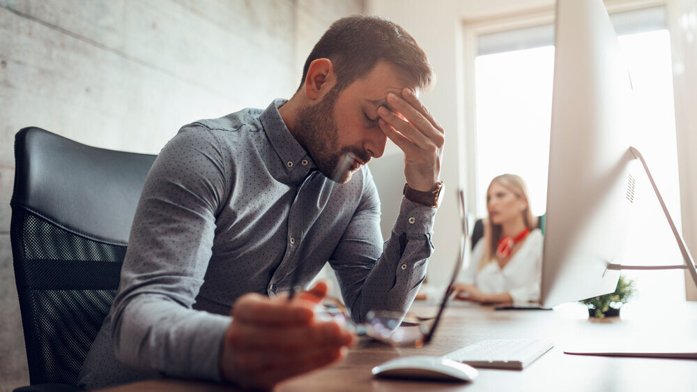 Ein Mann leidet unter Stress am Arbeitsplatz, Behörde, Amt. Ein Mann leidet unter Stress am Arbeitsplatz, Behörde, Amt.