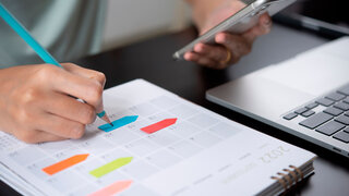 Urlaubsplanung mit Kalender und bunten Post Its.