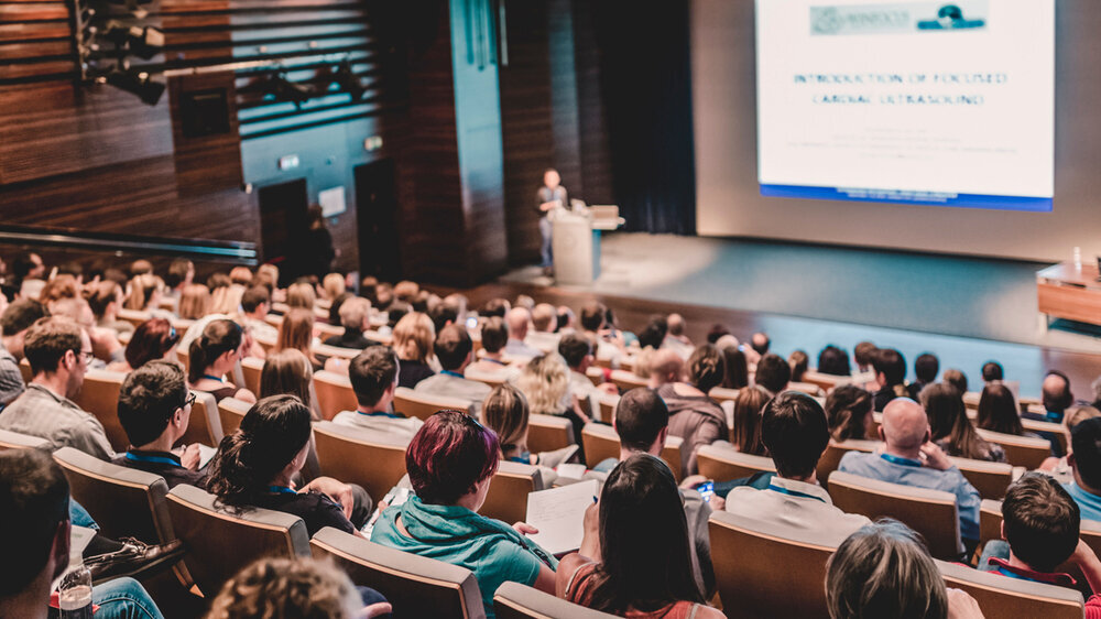Hörsaal einer Universität: Dozent spricht zu Studierenden.