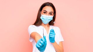 Zahnmedizinische Fachangestellte hält Werkzeuge isoliert auf rosa Hintergrund
