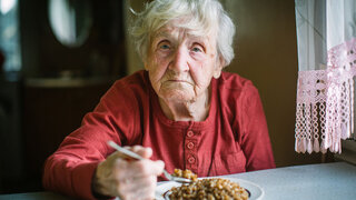 Alte Frau mit Essen