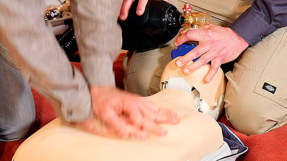 Kapitel 3: Reanimation: „Beide Hände übereinander mit ausgestreckten Ellenbogen im rechten Winkel über das Sternum legen“, empfiehlt Pahl. „Drücken Sie mit festem Druck das Brustbein 5 bis 7 cm ein, geben Sie in schnellem Rhythmus 30 Stöße.“ Die Atemmaske des Ambu-Beutels sollte fest über Mund und Nase gelegt, der Kopf nach hinten überstreckt werden, damit die Luftwege frei sind. Zwei Mal beatmen – das übernimmt möglichst der Zweithelfer. Im 30:2-Rhythmus so lange reanimieren, bis der Patient eigenständig Luft holt oder der Notarzt eingetroffen ist. Bei Kraftverlust wechseln sich die Helfer ab. |