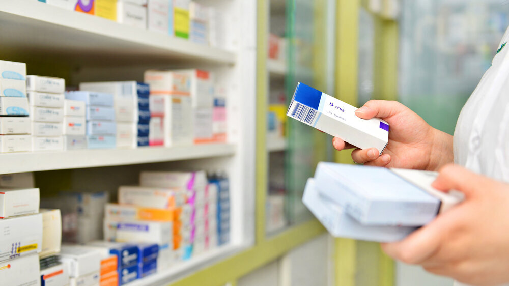 Pharmacist holding medicine box in pharmacy drugstore. Pharmacist holding medicine box in pharmacy drugstore.