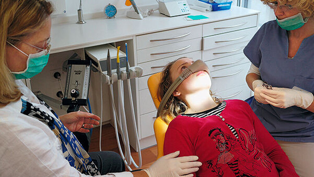 Dr. Jacqueline Esch (links) bei einer Lachgassedierung in ihrer internationalen Gemeinschaftspraxis für Kinderzahnheilkunde und Kieferorthopädie in München. Esch betont, dass Zahnärzte, die Lachgas anwenden wollen, auch solide im Bereich Verhaltensführung ausgebildet sein sollten. |